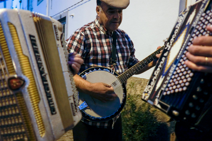Un homme qui joue du banjo entouré d'accordéonistes