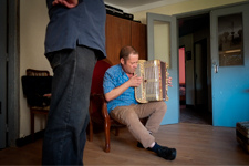 Un homme qui joue de l'accordéon dans une maison
