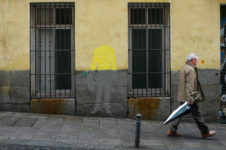 Homme qui marche dans la rue avec un parapluie