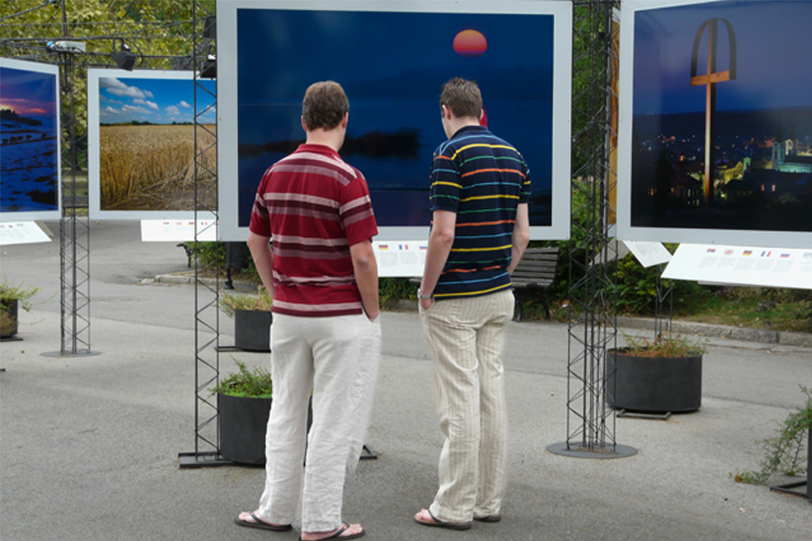 Deux hommes devant une photographie en exposition